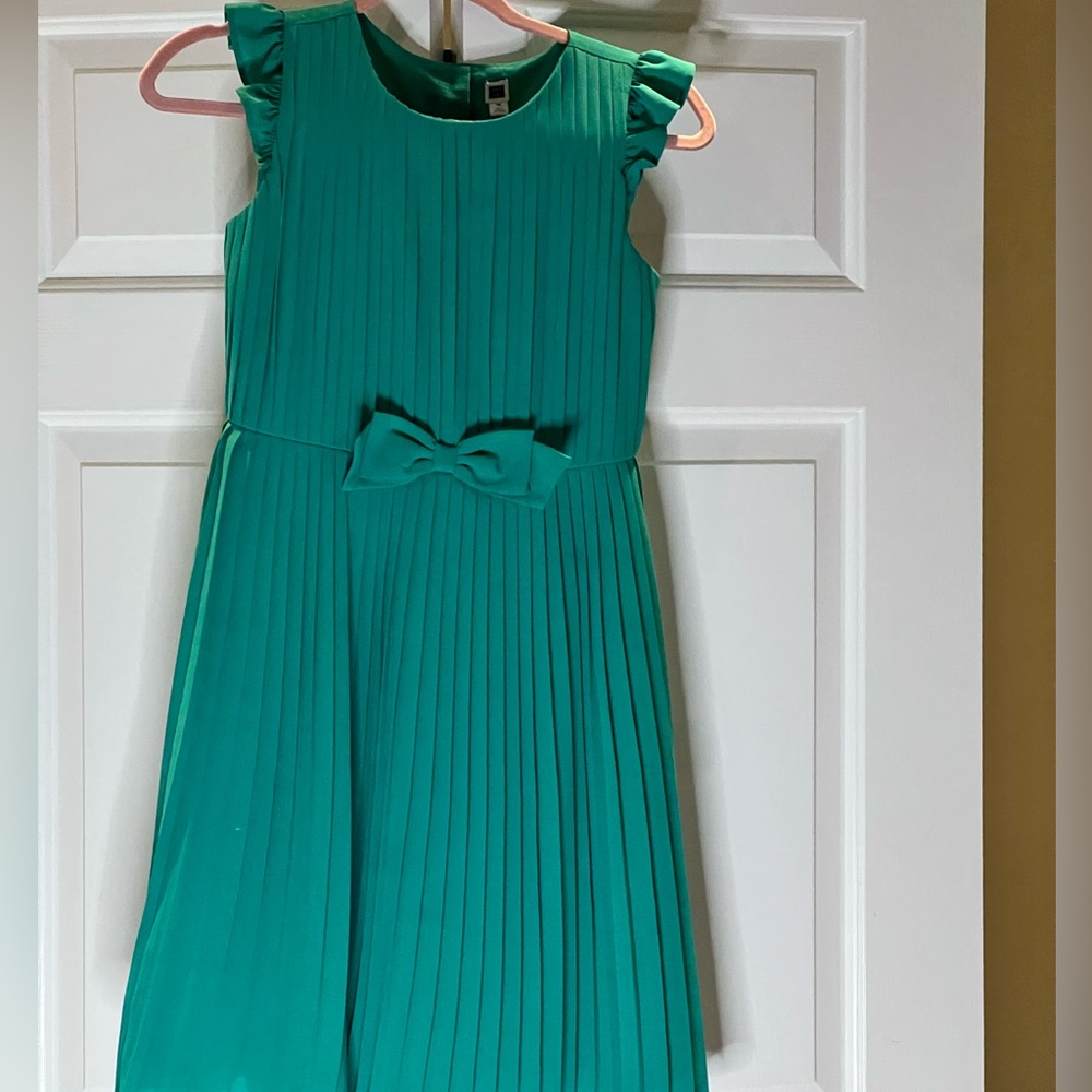Green pleated lined dress with bow on the front and also pleated on the back.
